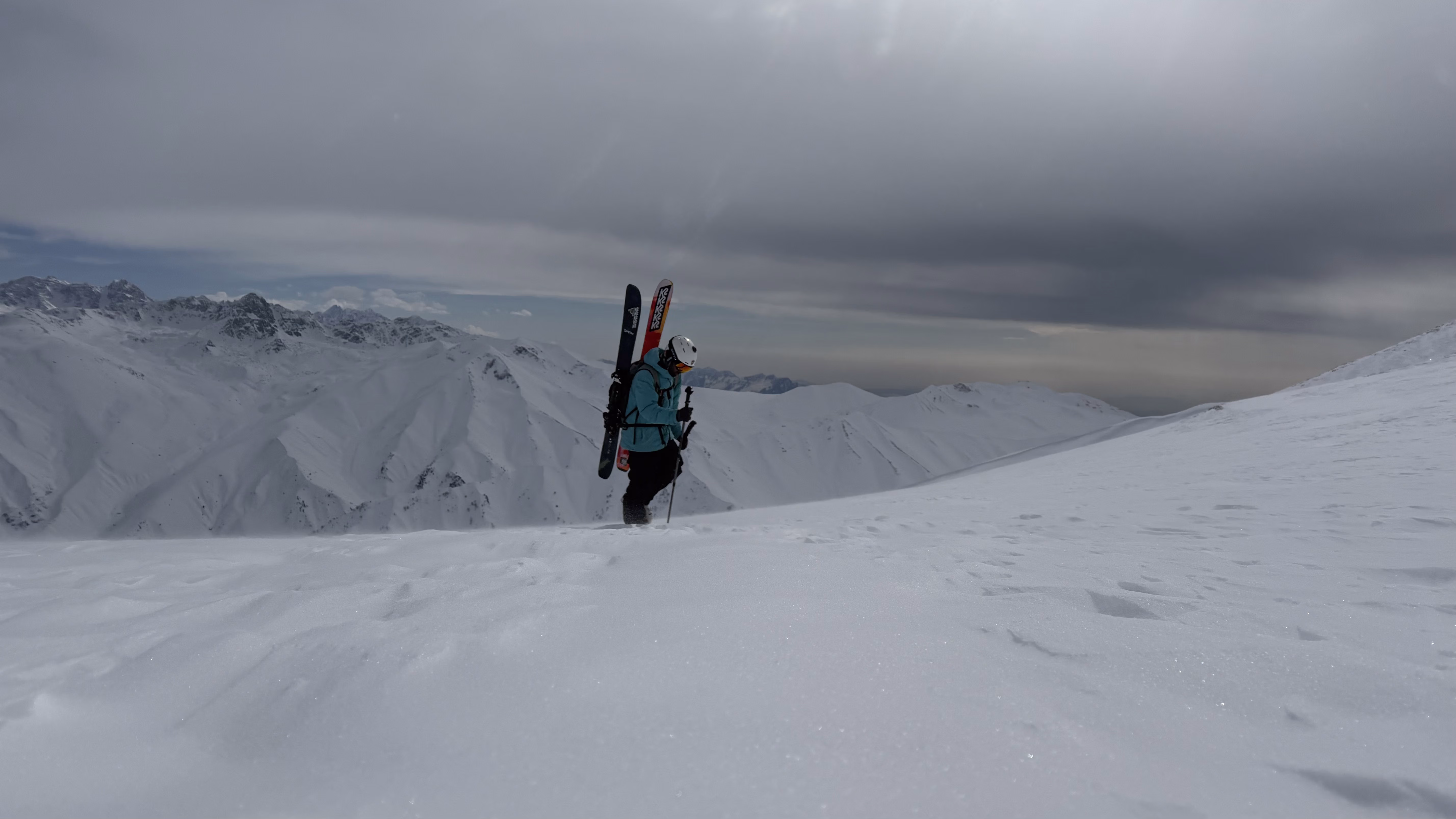 Ski tourer skinning uphill across a high snowfield above Gulmarg