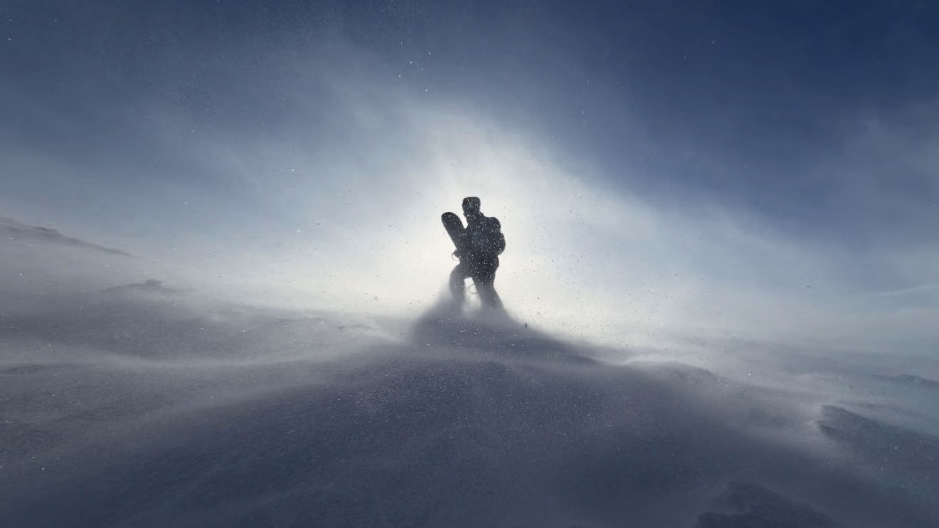 Splitboarder touring uphill across a remote snowfield above Gulmarg