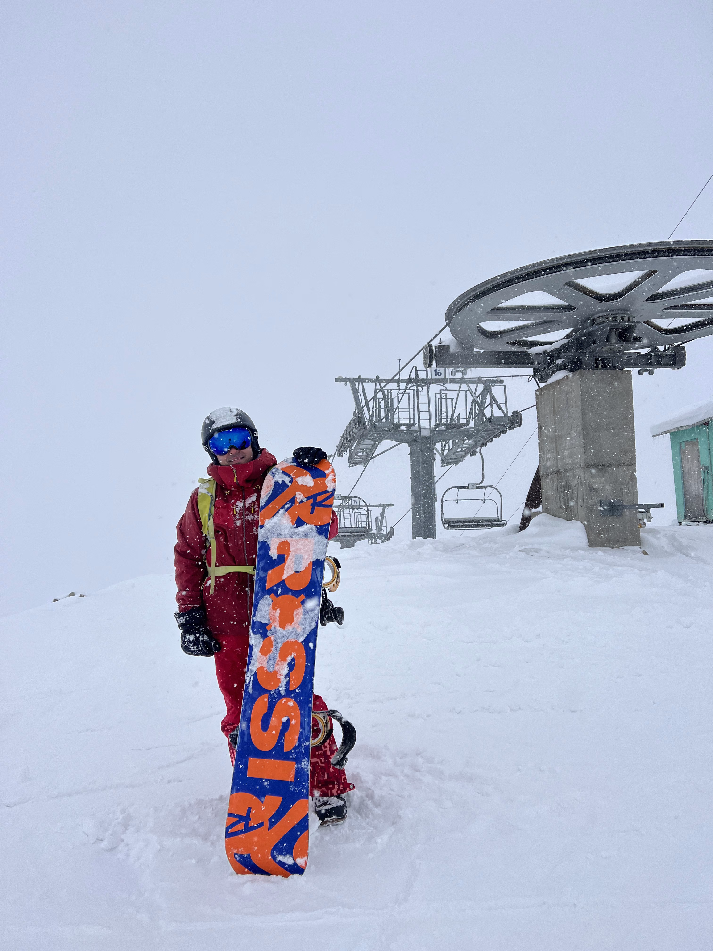 Learner snowboarder linking turns on a wide beginner run