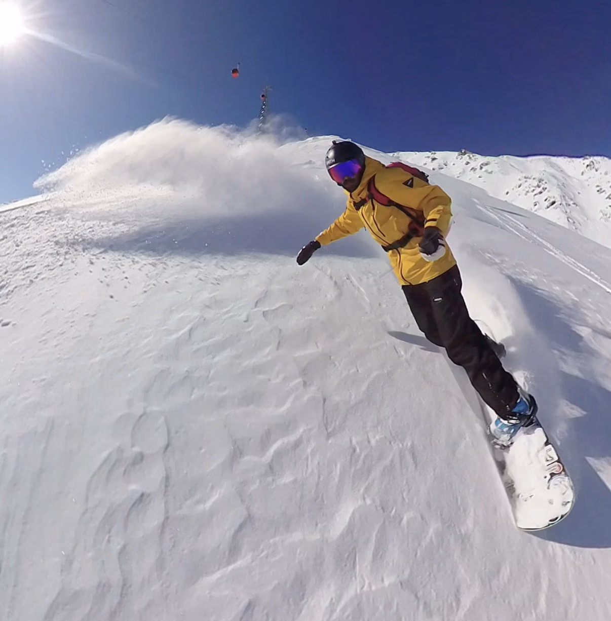 Freeride snowboarder riding fresh powder off the Gulmarg gondola