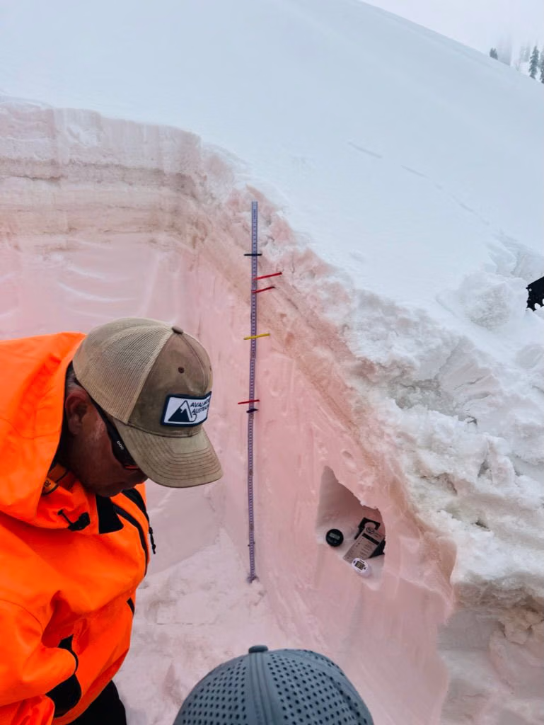 Guide checking avalanche safety equipment before heading into the terrain