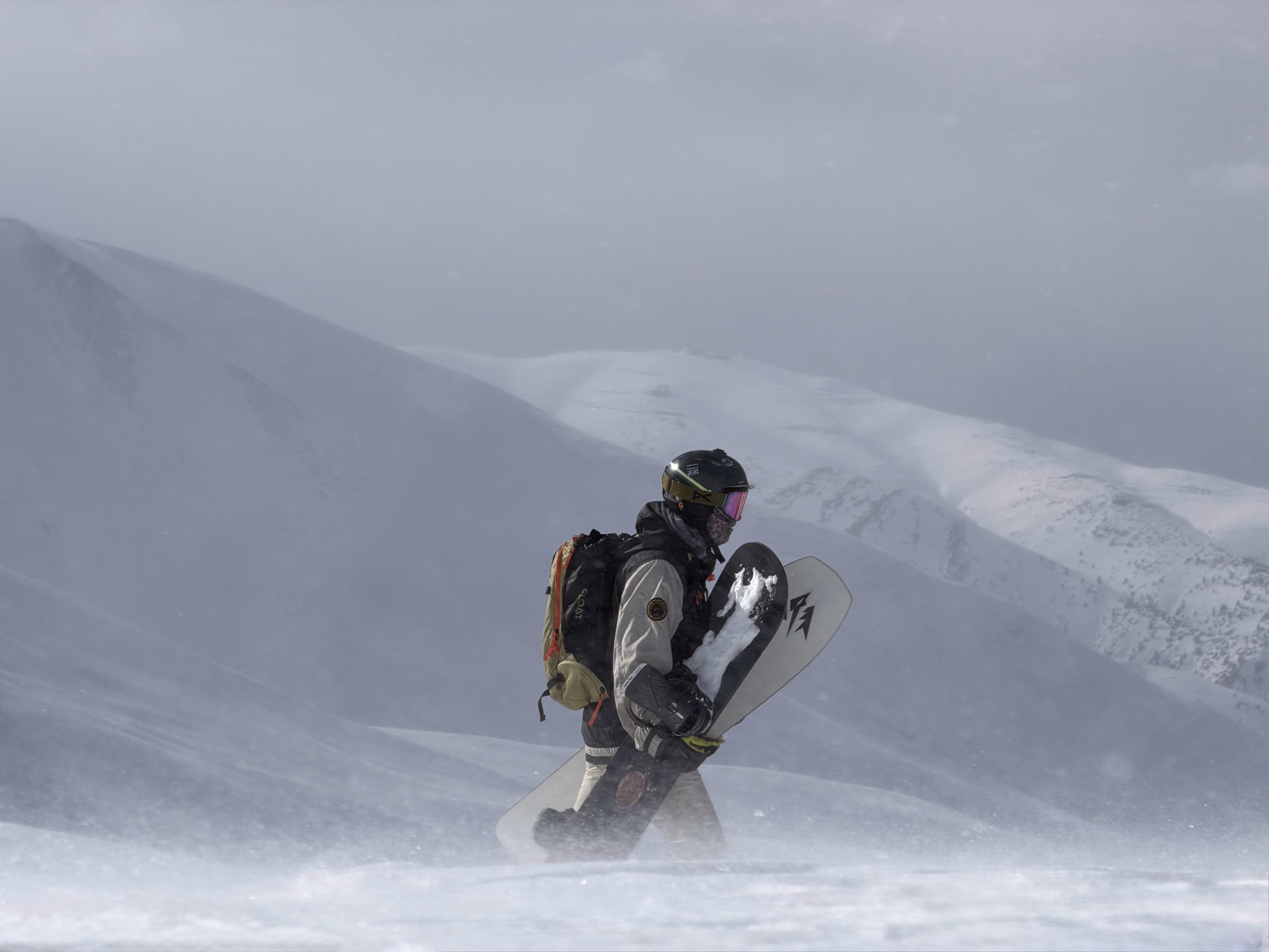 Snowboarder riding deep powder below the Apharwat ridgeline